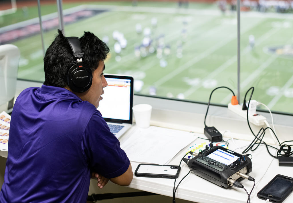 Sports media student audio engineering at a football game