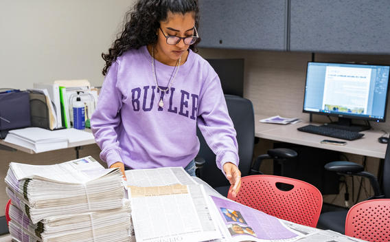 Journalism student sorting newspapers